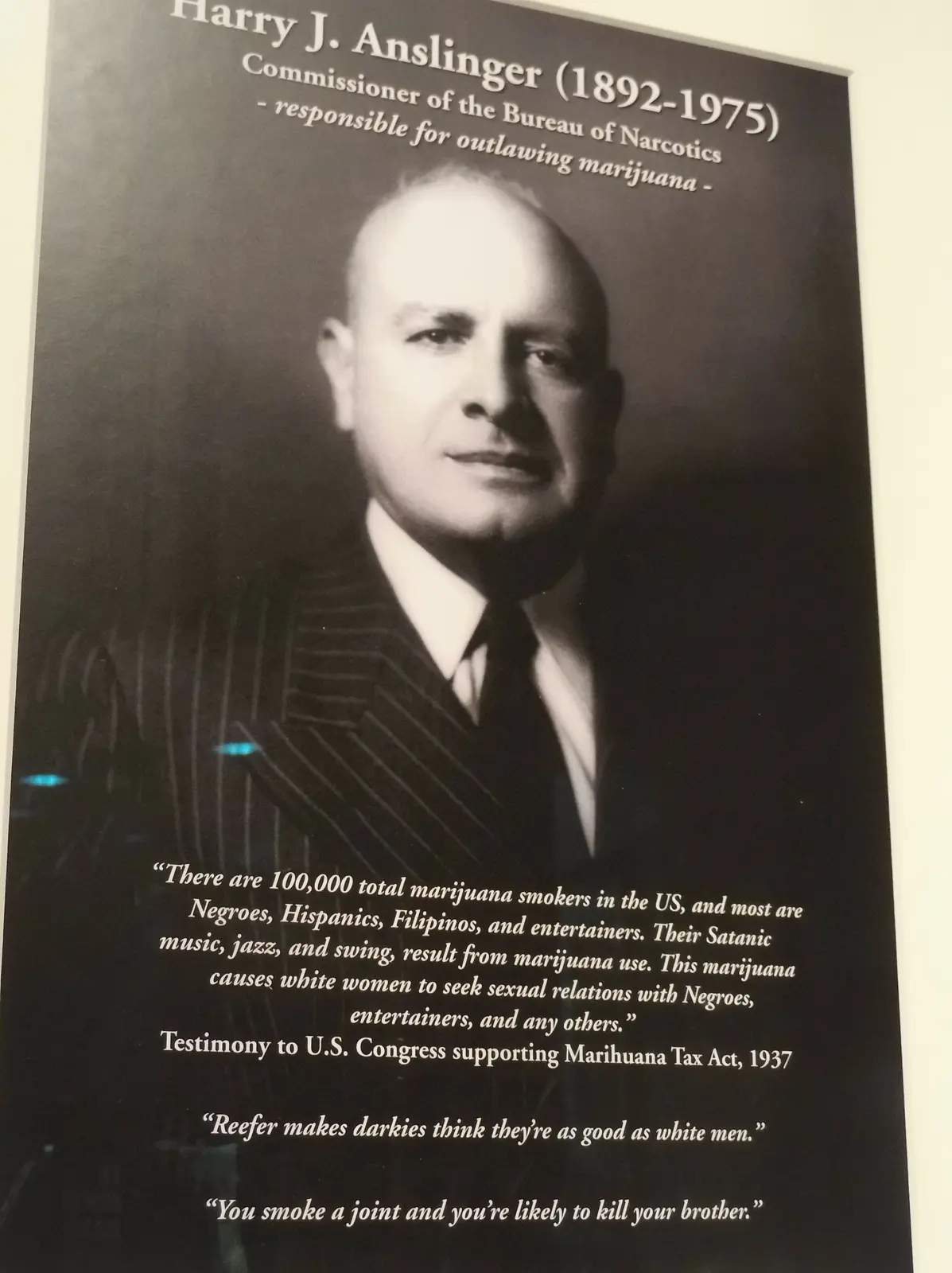 Painel museológico com retrato de Harry J. Anslinger e exemplos de retórica proibicionista histórica